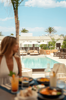Mujer comiendo en la piscina de Attitude Gandía